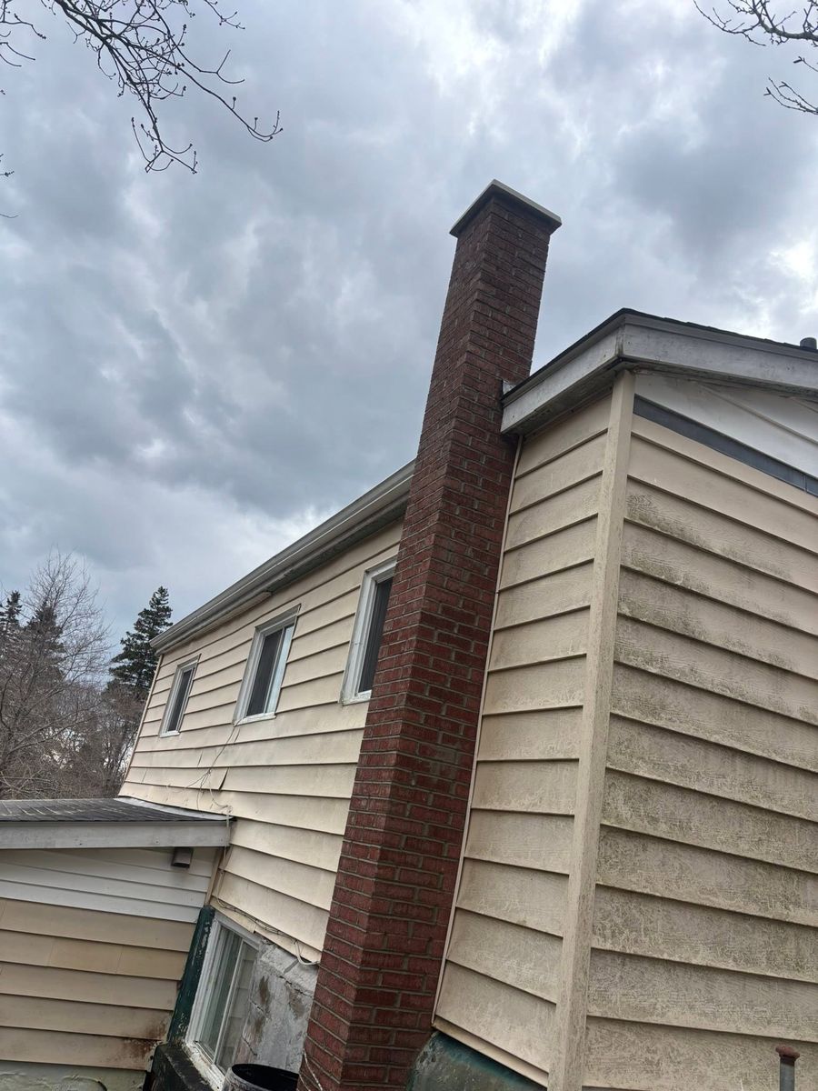 Full-height red brick chimney running up the gable end of a house