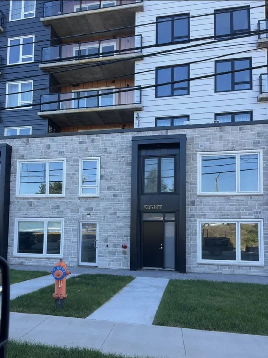 Grey stone veneer across the ground floor of a new apartment building